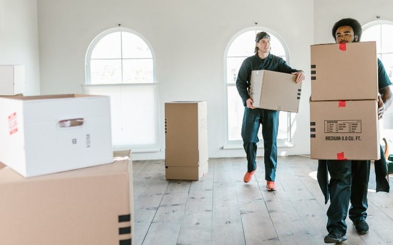 Equipo de vaciados de pisos trabajando en Salamanca Dos operarios del equipo retirando cajas y enseres del salón de una vivienda