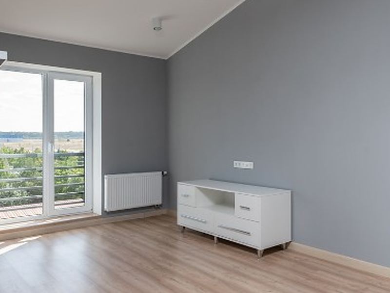 Dormitorio vaciado en Salamanca Dormitorio vacío con suelo laminado y ventana al exterior tras el vaciado