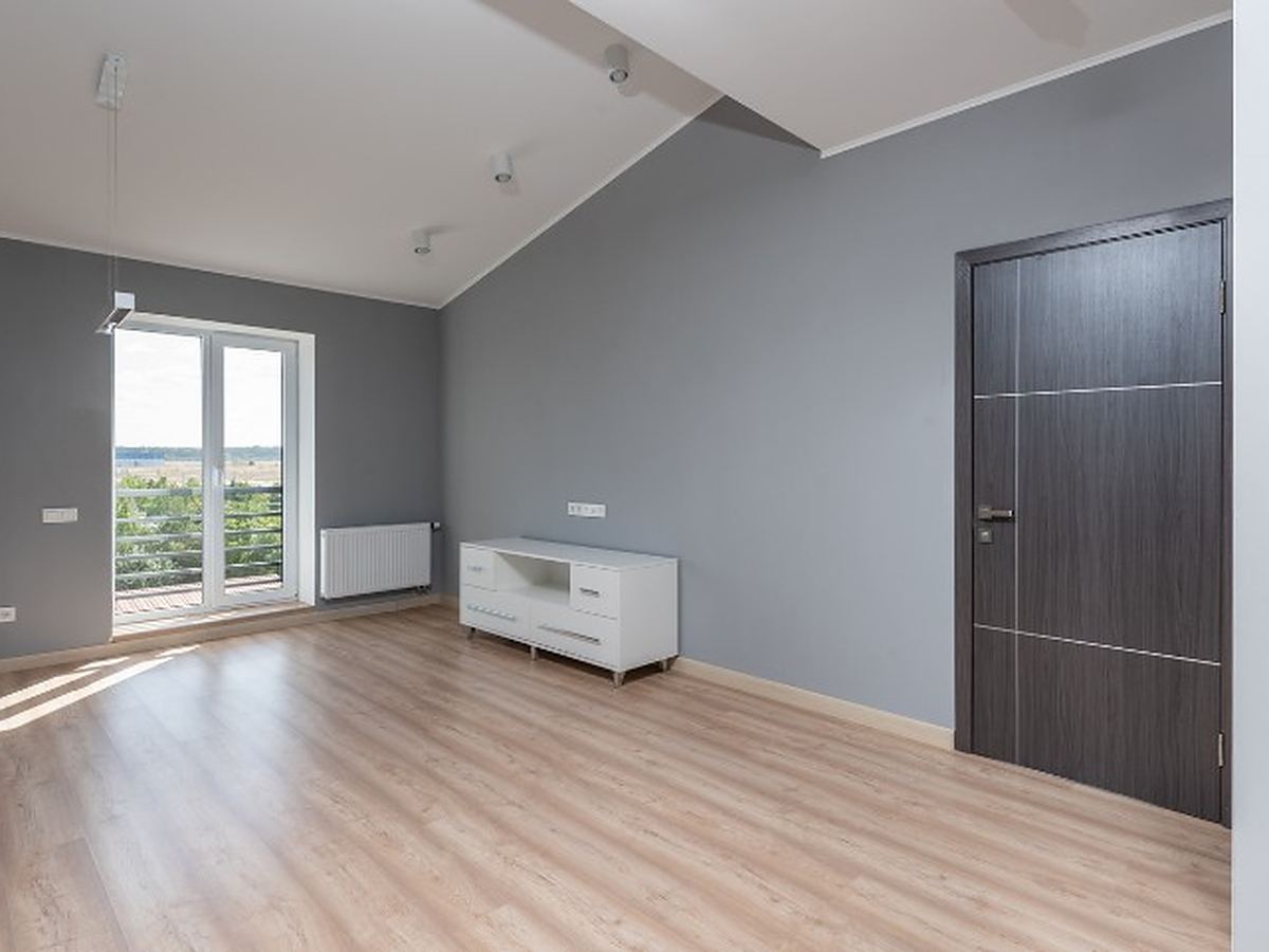 Vaciado de pisos en Béjar Dormitorio vacío de una vivienda en Béjar, con suelo laminado y salida al balcón