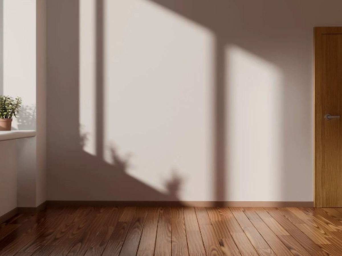 Vaciado de pisos en Guijuelo Habitación vacía con suelo de madera y plantas en la ventana, en Guijuelo